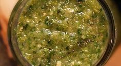 a glass jar filled with green food on top of a table