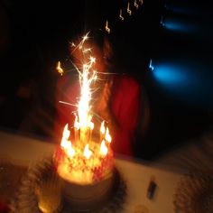 a woman blowing out candles on a cake with music notes coming out of the top