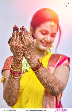 a woman in yellow holding her hands up to show off her hendi and jewelry