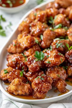 a white plate topped with chicken wings covered in sauce