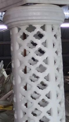 a close up of a white plastic object with holes in the middle and other items behind it