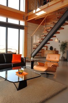 a living room with two couches and a coffee table in front of a stair case