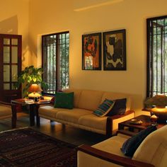 a living room filled with furniture and two lamps on either side of the couches