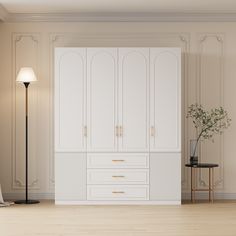 an empty room with white cabinets and a lamp on the floor next to a chair