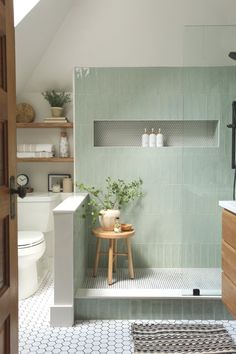 a white toilet sitting next to a bath tub in a bathroom under a roof with a skylight