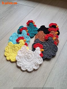 several crocheted chicken coasters sitting on the floor