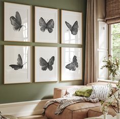 a living room filled with furniture and pictures on the wall above it's windows