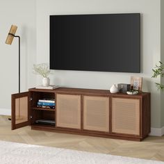 an entertainment center with a flat screen tv mounted on the wall and wicker doors