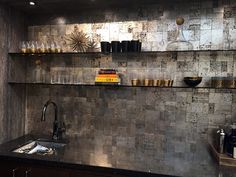 an industrial style kitchen with stainless steel walls and shelving above the sink, is shown