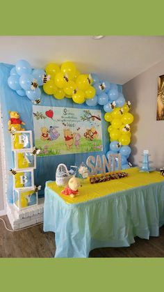 a winnie the pooh birthday party with balloons and honeybees on it's wall