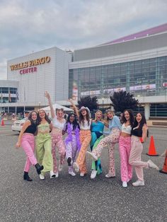 a group of women standing next to each other in front of a shopping center building