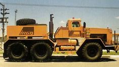 a large yellow truck parked on top of a parking lot