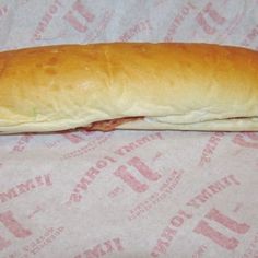 a long sub sandwich sitting on top of a wrapper