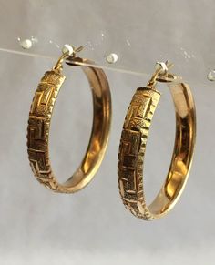 These vintage hoop earrings are 14K gold. Their total weight is 7.76 grams and they are 1.5 inch in diameter. The band is .25 inch wide with an attractive design. These earrings for pierced ears have a latch back. Classic Yellow Gold Hoop Clip-on Earrings, Anniversary Yellow Gold Clip-on Hoop Earrings, Formal Gold Hinged Hoop Earrings, 14k Gold Hinged Hoop Earrings For Formal Occasions, Clip-on Round Hoop Earrings In Yellow Gold, Formal Yellow Gold Hoop Clip-on Earrings, Formal Engraved Hoop Jewelry, Engraved Yellow Gold Hoop Jewelry, Vintage Pierced Hoop Earrings For Anniversary