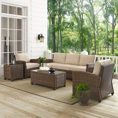 an outdoor living room with wicker furniture and wood flooring on the outside deck