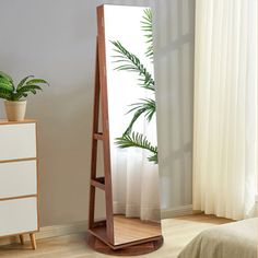 a mirror sitting on top of a wooden shelf next to a bed