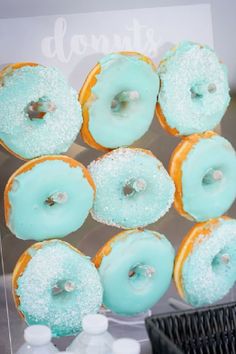 there are many doughnuts on display in the store window, with frosting and sprinkles all over them