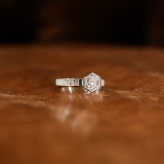 a diamond ring sitting on top of a wooden table