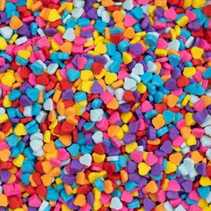 multicolored heart shaped confetti sprinkles scattered on top of each other