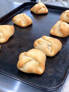 six pastries on a baking sheet with toothpicks sticking out of the top