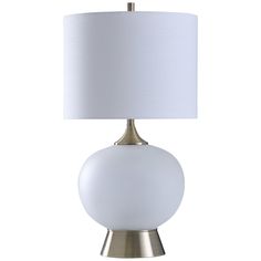 a table lamp with a white shade on the base and a silver metal frame around it