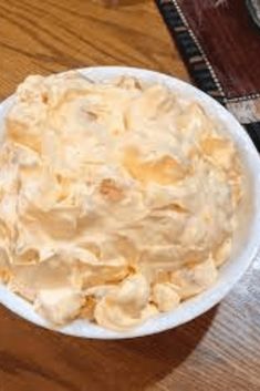 a white bowl filled with food on top of a wooden table