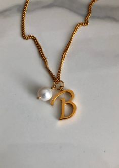 Letter B necklace, set on a stainless steel ,golden color chain. With addition cost there is an option to add a white freshwater pearl, as a charm, next to the letter. 6 mm, white round pearl Kindly choose your option. Beautiful spiritual gift. chain length 18'. Please make sure you to pay attention to the size of the pendant. I have added pictures next to 25 cent coin, and measurement tape.  Need a different length just write it to me in the "message to the seller" box of the order form. **LIMI Elegant Initial Necklace With Pearl Charm As Gift, Elegant Initial Necklace With Pearl Charm For Gifts, Gift Pearl Chain Necklace With Initial Pendant, Pearl Chain Necklace With Initial Pendant Gift, Initial Necklace With Pearl Pendant For Gift, Initial Pendant Necklace With Pearl For Gift, Pearl Pendant Initial Necklace As Gift, Dainty Pearl Necklace With Initial Pendant Gift, Gold Dainty Pearl Necklace With Initial Pendant