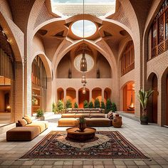 the interior of a large building with high ceilings and arched windows, couches, rugs and potted plants