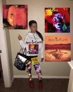 a woman standing next to a wall with pictures on it and holding a handbag