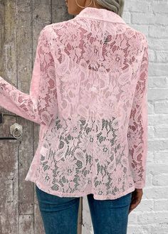 a woman wearing a pink lace blouse and jeans