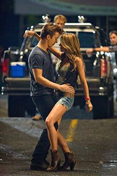 a man and woman dancing on the street