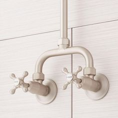 two faucets are attached to the side of a wall