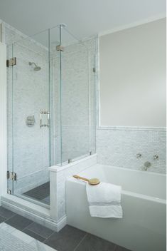 a white bath tub sitting next to a walk in shower