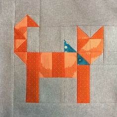 an orange dog made out of fabric on a piece of gray material with white polka dots