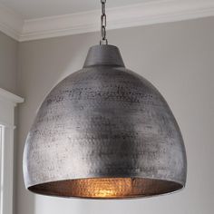 a large metal light hanging from a ceiling