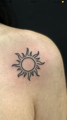 a small sun tattoo on the back of a man's left shoulder and chest