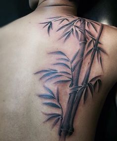 the back of a man's shoulder with bamboo leaves on it