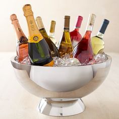 a silver bowl filled with bottles of wine