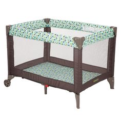 a baby crib that is on wheels and has a blue and green cover over it