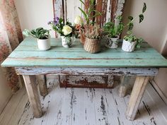 several potted plants are sitting on an old table