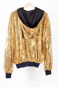 Gorgeous Gold Rush Bomber Jacket. Handmade in limited quantity, this jacket is beautifully made, with the shiniest of gold sequin material, hooded, with quality cuffs and lining. A firm favourite, and perfect for the festive season! Available in S 8-10-12 UK Size, L 14-16-18 Winter Tops With Contrast Sequin, Winter Contrast Sequin Tops, Gold Sequined Outerwear For Winter, Winter Glitter Long Sleeve Outerwear, Trendy Hooded Outerwear For Party, Long Sleeve Outerwear For Party And Festival, Long Sleeve Sequined Outerwear For Festivals, Hooded Fall Party Outerwear, Gold Sequin Jacket