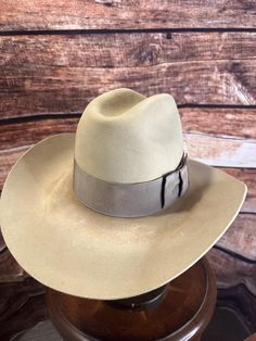 Vintage Stetson 4X Beaver Western Hat - Size 7 1/4, distressed.  ### Full Description: Step into timeless Western style with this vintage Stetson 4X Beaver felt hat. Made from a high-quality beaver blend, this hat showcases the craftsmanship and durability that Stetson is known for. The light tan color adds a classic touch, perfect for any Western or vintage enthusiast.  This hat features a wide brim and a traditional pinched crown, complemented by a matching grosgrain ribbon band with a stylish bow, enhancing its elegance. The inside of the hat is lined with a satin finish, bearing the iconic Stetson logo, and the leather sweatband ensures a comfortable fit.  This Stetson 4X Beaver hat is in excellent vintage condition, showing minimal signs of wear and preserving its shape and color beau Vintage Fitted Felt Hat For Ranch, Vintage Fitted Fedora For Ranch, Fitted Vintage Fedora For Ranch, Vintage Flat Bill Hat For Country Events, Vintage Fitted Hat For Ranch, Fitted Vintage Hat For Ranch, Vintage Ranch Hats With Curved Brim, Vintage Curved Brim Ranch Hats, Custom Fitted Hat For Western-themed Events