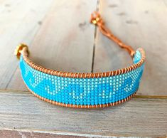 a blue beaded bracelet sitting on top of a wooden table