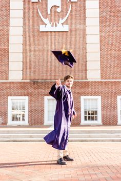 a young boy in graduation gown throwing his cap into the air