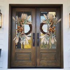 two brown double doors with wreaths on them