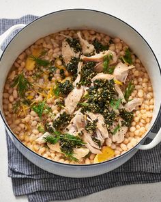 a pot filled with chicken and beans on top of a table