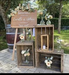 some wooden crates with flowers and candles in them