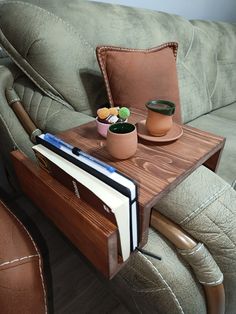 a wooden table with two cups and a book on it next to a couch in a living room