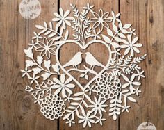 a wooden cutout of a heart surrounded by flowers and birds on a wood background