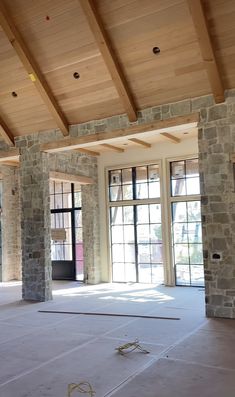 an empty room with stone pillars and windows